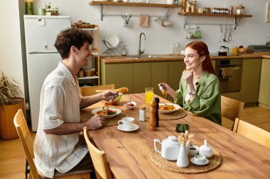 Genç bir çift evde birlikte vakit geçirmeyi, gülümsemeyi ve lezzetli bir yemeği paylaşmayı sever..