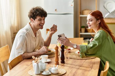 Sevgi dolu bir çift, sıcak yemek masasında ev yapımı bir yemek yerken keyifli sohbetler eder..
