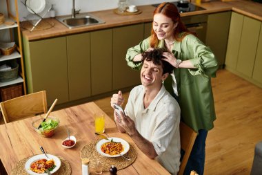 Sevgi dolu bir çift, evde lezzetli bir yemeğin tadını çıkarırken birlikte kahkaha ve kaliteli zaman geçirir..