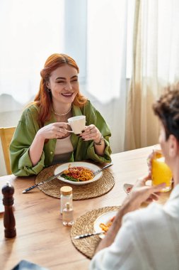 İki genç aşık birlikte keyifli bir yemeğin tadını çıkarıyor, gülümsüyor ve evde vakit geçiriyorlar..