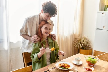 Genç bir çift sıcak bir yemeği paylaşır, sıcak evlerinde keyif ve bağlantının tadını çıkarırlar..