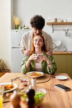 Genç bir çift lezzetli bir yemeğin ardından sıcak bir anın tadını çıkarır..