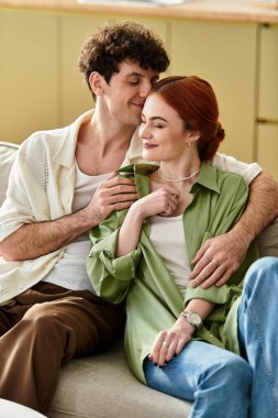 Genç bir çift, sıcak evlerinde gülümseyen ve kucaklaşan hassas anları paylaşır..