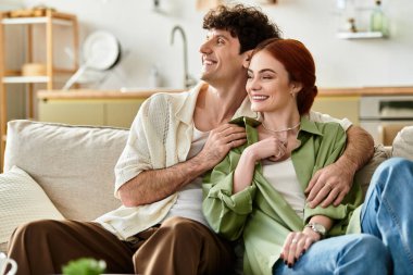 Çiftler rahat bir kanepede sevinçle kucaklaşır, evlerinde samimi anları ve aşkları sevgiyle anarlar..