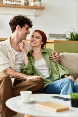 Genç bir çift birbirlerine gülümsüyor, evde birlikte vakit geçiriyorlar..