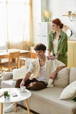 Mutlu bir çift kanepede birlikte oturur, sıcak evlerinde aşklarını paylaşırlar..