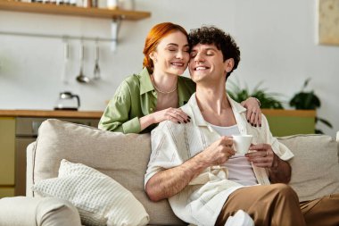 Genç bir çift sıcak yaşam alanlarında kahkaha ve sıcaklık paylaşıyor, çay içip kaynaşıyorlar..