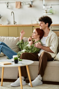 Genç bir çift, evlerinde kanepede yatarken kahkaha ve sevgiyi paylaşıyor..