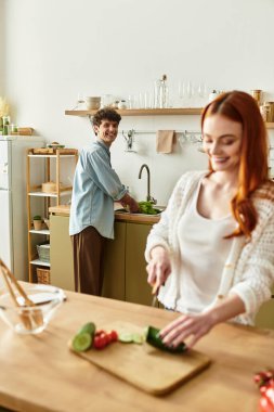 Genç bir çift evde birlikte yemek pişirirken neşe ve bağı paylaşıyor..