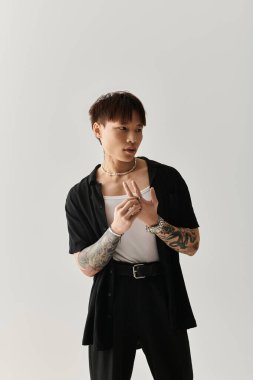 Genç yakışıklı Asyalı bir adam, kendine güvenini ve tarzını vurgulayarak poz verir..