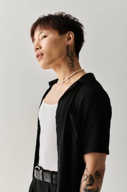 Yakışıklı Asyalı genç adam moda anlayışını moda kıyafetleri ve çarpıcı aksesuarlarıyla sergiliyor..