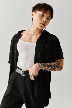 İleri moda genç adam, gösterişli dövmeleri olan gösterişli ve şık bir şekilde poz veriyor.