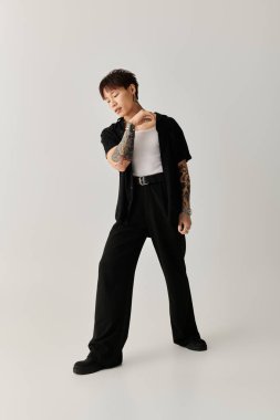 Genç adam çarpıcı tarzını ve tavrını modern ve şık bir ortamda sergiliyor..