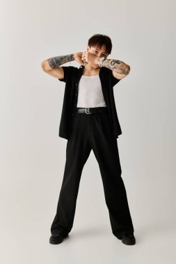 Genç ve yakışıklı Asyalı bir adam şık kıyafetini minimalist bir arka planda sergiliyor..