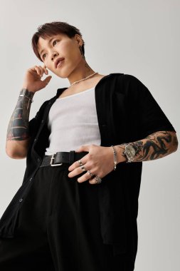 Havalı Asyalı adam, kapalı alanda düşünceli bir duruş sergilerken eşsiz moda anlayışını sergiliyor.