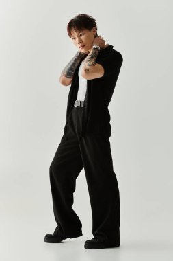 Şık, genç Asyalı bir adam şık bir elbise içinde kendine güvenerek duruyor. Havalı bir tarzı ve karizması var..