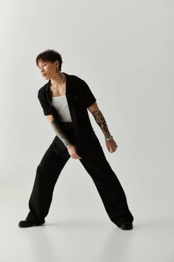 Modern bir stüdyoda, genç yakışıklı bir Asyalı kendine güvenen bir şekilde poz verirken kendine has tarzını sergiliyor..