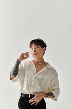 Genç, yakışıklı Asyalı bir adam moda anlayışını minimalist bir stüdyoda sergiliyor..