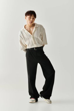 Genç adam zarif ve rahat bir şekilde harmanlanmış şık bir kıyafet sergiliyor..