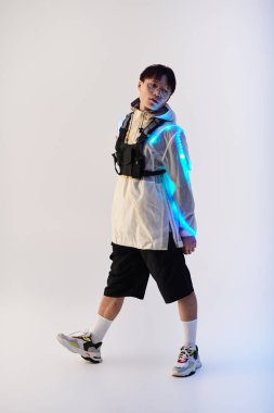 Genç bir Asyalı, şık bir elbiseyle ve parlak aksesuarlarıyla evin içinde gösteriş yapıyor..