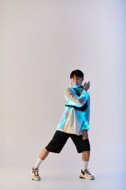 Yakışıklı Asyalı genç bir adam kendine güvenerek duruyor, kendine has tarzını sergiliyor..