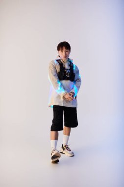 Yakışıklı Asyalı genç bir adam şık bir stüdyoda şık moda seçimleri sergiliyor..