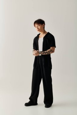 Genç, yakışıklı Asyalı bir adam hiç çaba harcamadan şık bir kıyafet içinde, cazibesi ve güveni ile ayakta duruyor..