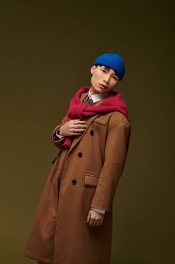 Şık bir genç adam kendine güvenerek poz veriyor, eşsiz yeteneğini cesur bir arkaplanda sergiliyor..