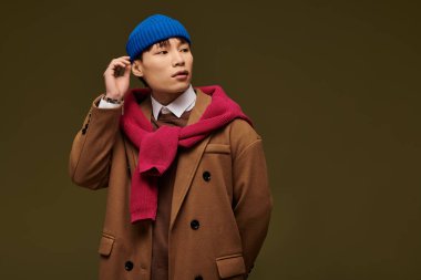 Mavi bereli ve şık kıyafetli genç yakışıklı bir adam benzersiz bir şehir görüntüsü sergiliyor..