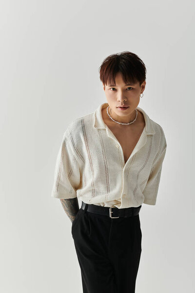 Уверенный молодой азиат стильно стоит в современной студии.