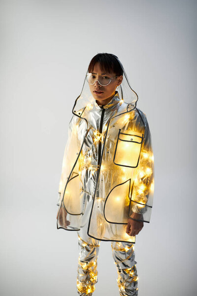 Молодой, красивый азиат уверенно стоит в ослепительном, привлекающем внимание наряде.