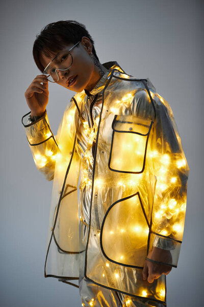 Модный молодой азиат уверенно позирует в светлом плаще, демонстрируя свой неповторимый стиль.