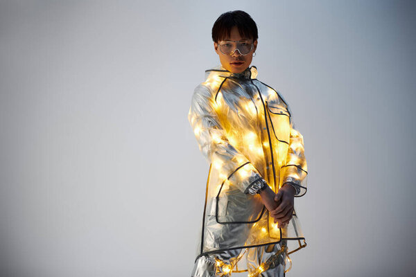 Молодой, стильный азиат демонстрирует свое ослепительное пальто, излучая уверенность.