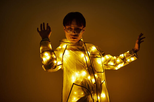 Молодой красивый азиат элегантно позирует в светящемся наряде, излучая очарование и уверенность.