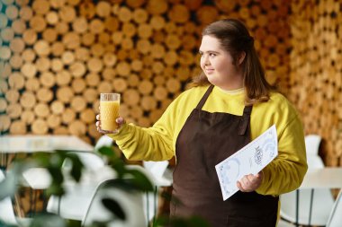 Neşeli bir kafede, kendine güveni tam genç bir kadın elinde meyve suyu ve menü ile müşterilerle meşgul olur..