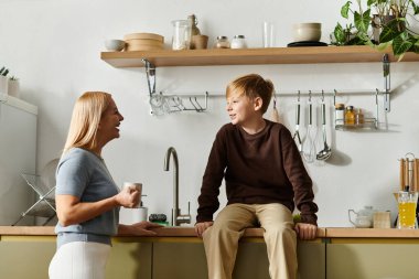 Bir anne ve oğlu mutfak tezgahında şakacı sohbetin tadını çıkarırlar..
