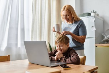 Neşeli bir anne, evlerinde eğlenirken oğluyla neşeyle etkileşime geçer..