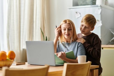 Anne ve oğlu, parlak mutfak ortamlarında birlikte yaratıcı bir öğrenme anını paylaşıyorlar.