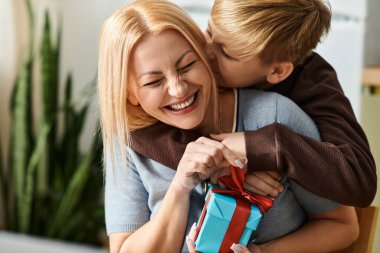 Bir kadın oğlunun güçlü bağlarını vurgulayan bir hediyeyle onu şaşırttığı için sevinir..