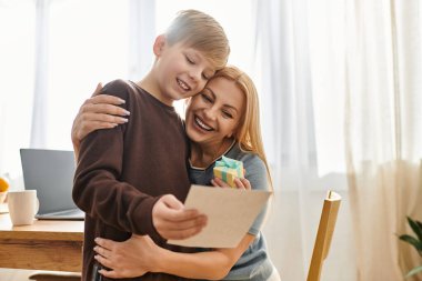 Anne ve oğul sevgi ve neşe dolu özel bir anı paylaşırken sıcak bir şekilde kucaklaşırlar..