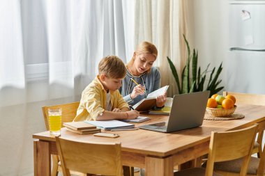 Bir kadın ve oğlu, o rahat bir masada ödevlerini yaparken aynı kahkahayı ve eğitimi paylaşıyorlar..