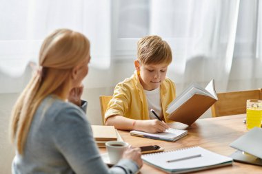 Bir anne ve oğlu sıcak bir öğleden sonrayı paylaşıyor, sessiz bir çalışma ve öğrenme üzerine bağ kuruyor..