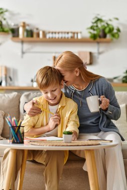 Anne ve oğul güneşli oturma odalarında birlikte sanat yaratırken keyifli bir anı paylaşıyorlar..