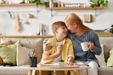 Bir anne ve oğul keyifli bir anı paylaşıyor. Rahat bir evde sanat yaratıyorlar..
