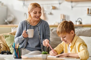 Bir anne, oğlunun resmini yaparken içmekten zevk alır..