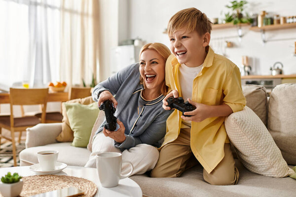 Laughing together, a mother and her son compete in a fun video game session at home.