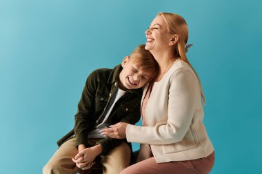 Bir anne ve oğul çocukluk ve anneliğin mutluluğunu kucaklayan samimi bir kahkahayı paylaşırlar..