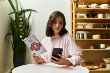 Genç bir kadın akıllı telefonunu kullanarak menüyü inceliyor, kafe deneyiminin tadını çıkarıyor..