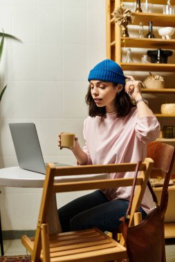 Güzel genç bir kadın modern bir kafede kahvesini yudumlarken uzak bir işe girişiyor..