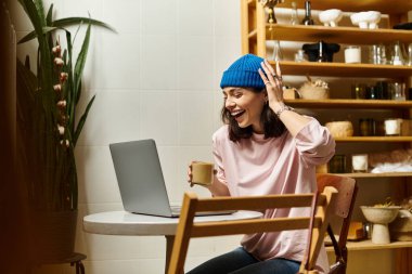 Neşeli genç bir kadın, şık bir kafe masasında oturmuş kahvesini yudumluyor..